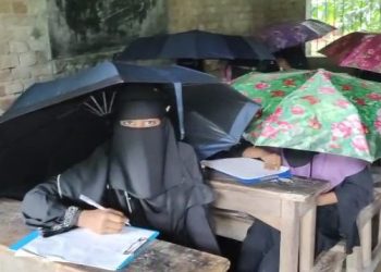 গলাচিপায় বাম হাতে ছাতা ডান হাতে কলম নিয়ে পরীক্ষা দিচ্ছে শিক্ষার্থীরা